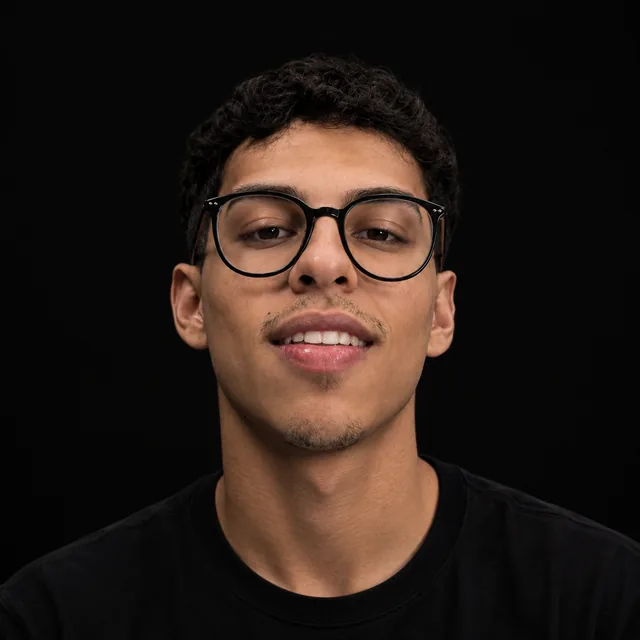 Elias Oliveira, de óculos e camiseta preta, sorrindo